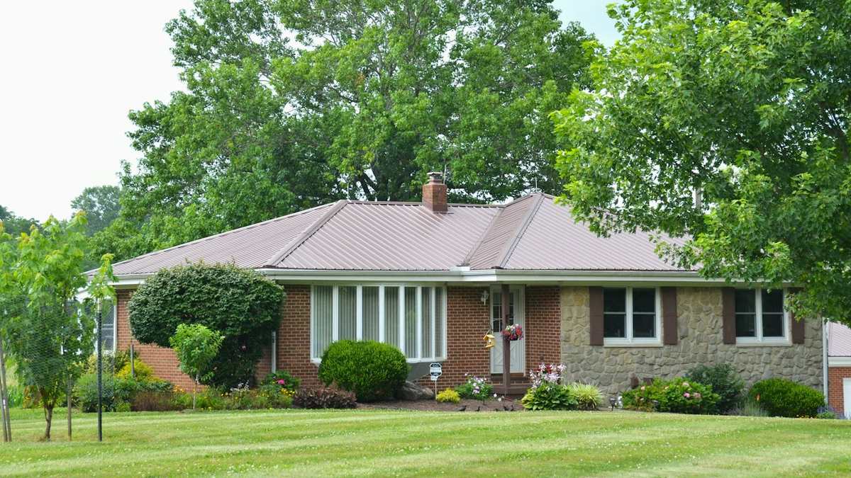 Brick single-storey rental home with a mature lawn and trees