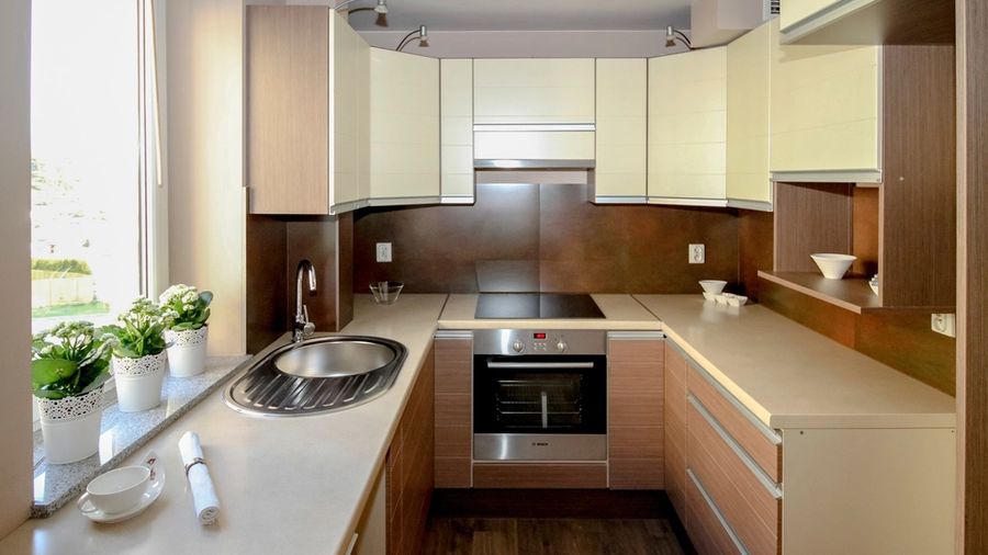 Compact modern condo kitchen with wood cabinets and stone counters