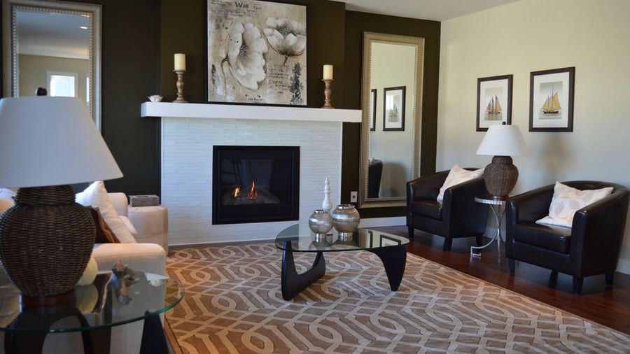 Furnished living room with a fireplace, armchairs and patterned rug