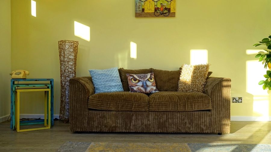 Sunlit furnished sitting room with a sofa and side tables